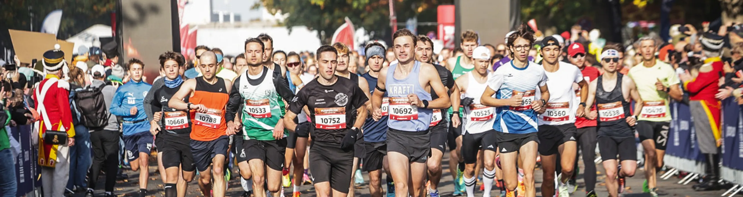 Teilnehmende laufen aus dem Startbogen