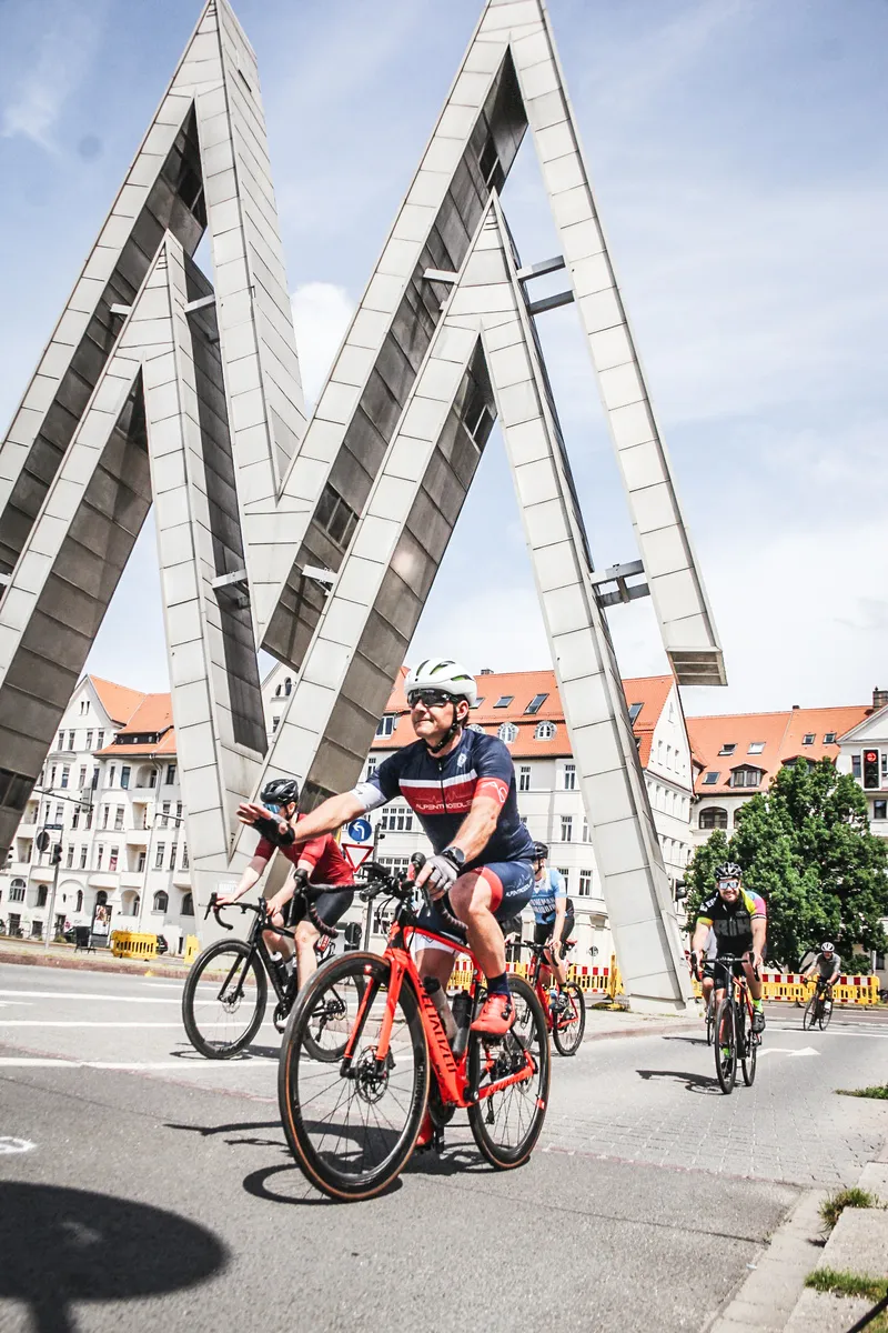 Rennradfahrer fahren durch das Doppel-M an der alten Messe