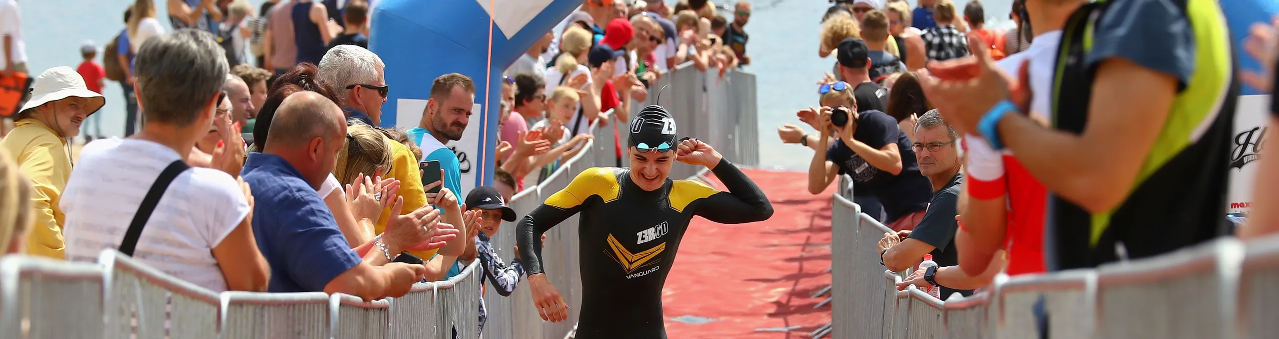 Teilnehmer läuft vom Wasser durch das Zieltor