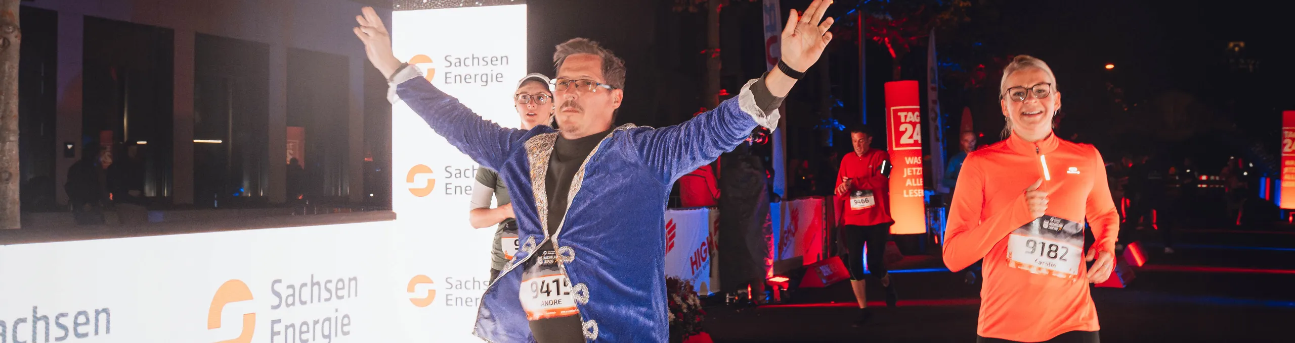 Mann in einem blauen Kostüm, der in ein erleuchtetes Zieltor einläuft