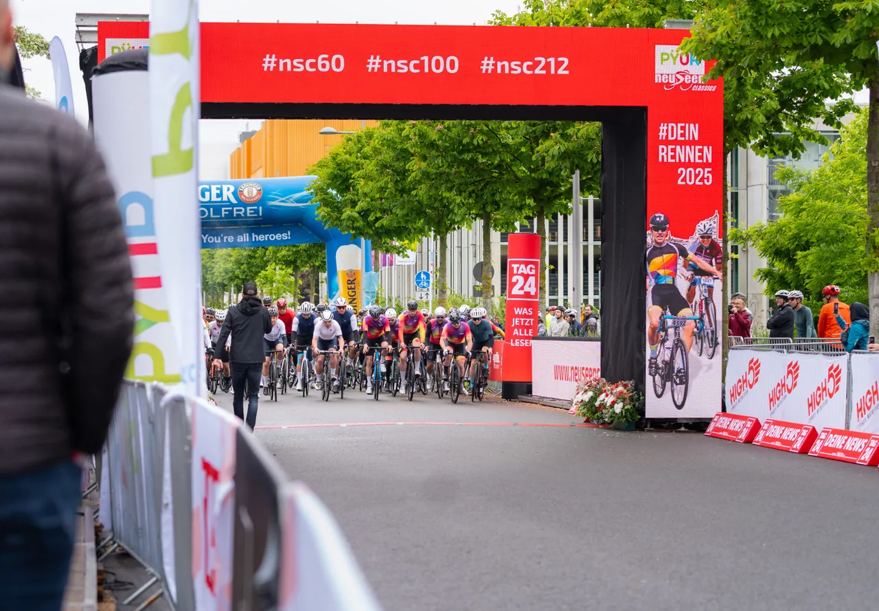 Blick durch den Zielbogen auf anfahrende Rennradfahrer