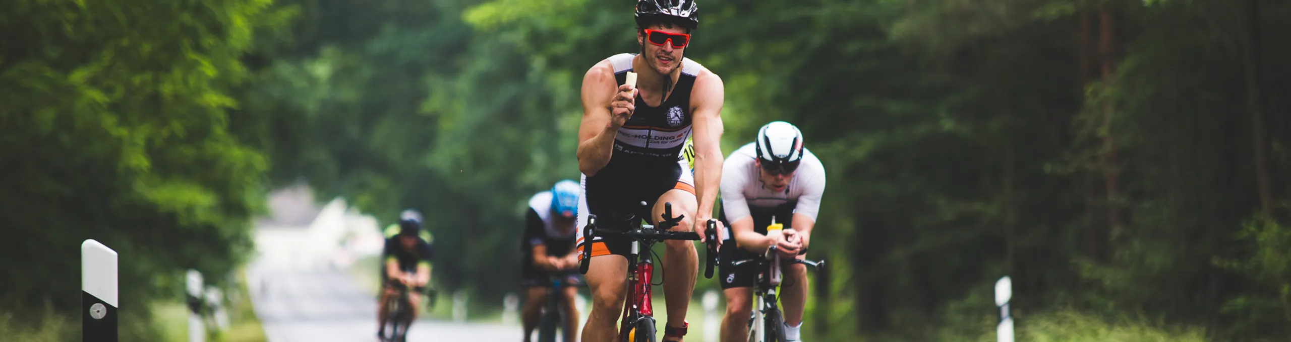 Rennradfahrer auf einer Straße im Wald